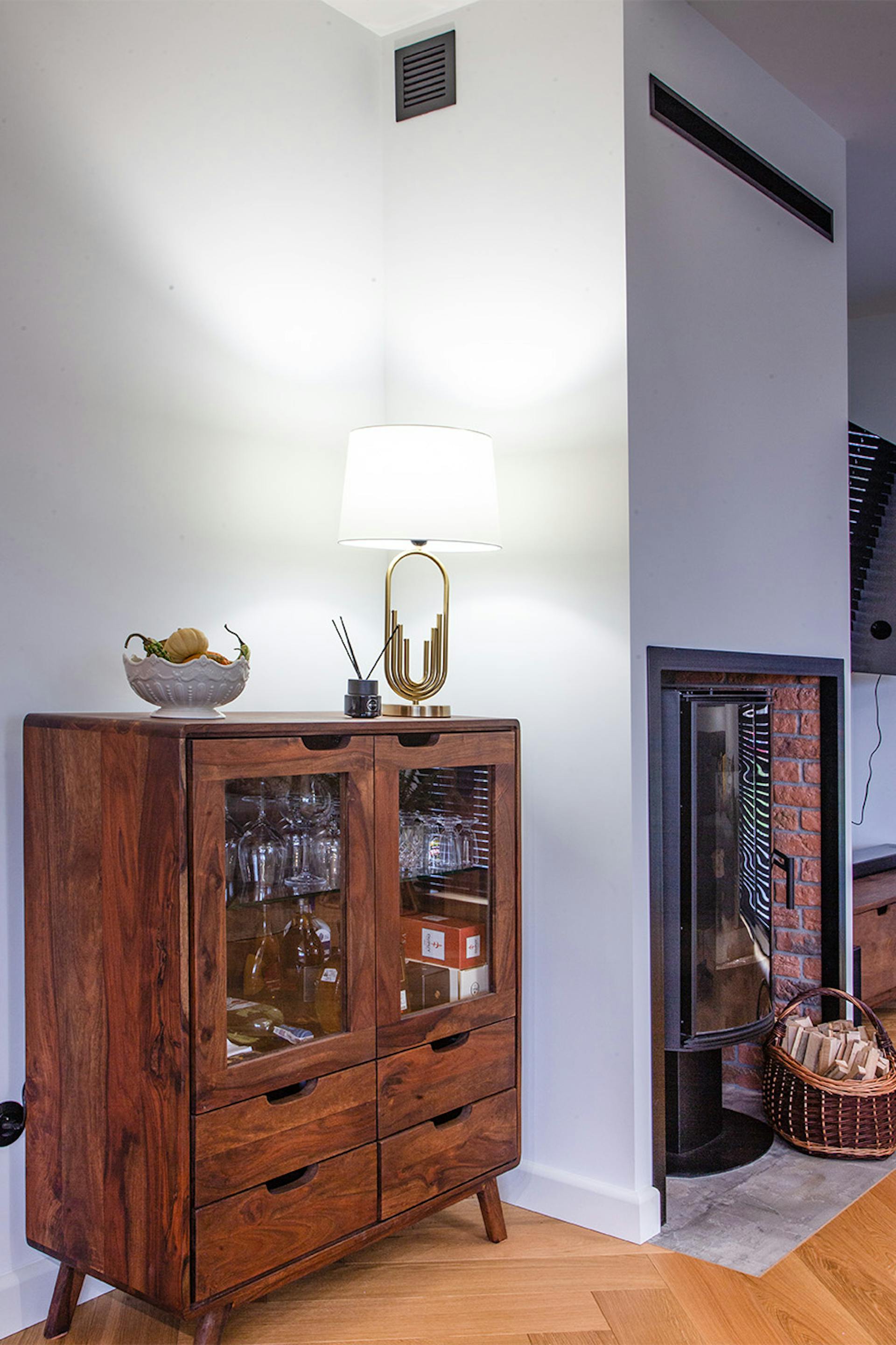 drewniana witryna z szufladami i przeszklonymi frontami na tle białej ściany