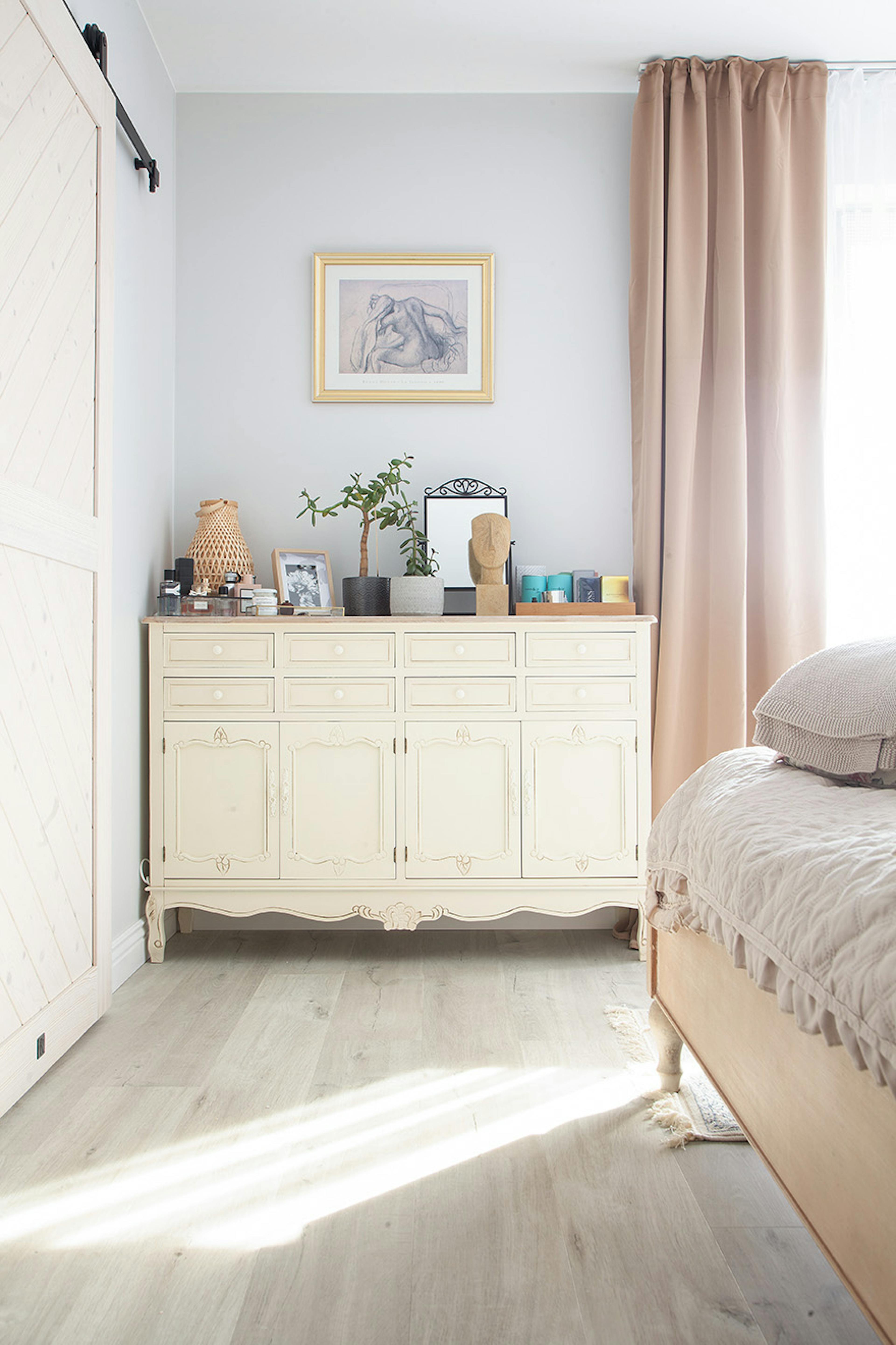 cremefarbene Kommode mit dekorativem Stuck in einem hellen Schlafzimmer