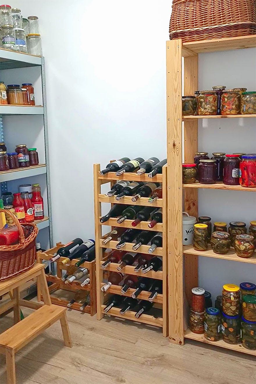 Holzregale gefüllt mit Konserven in einer kleinen Speisekammer