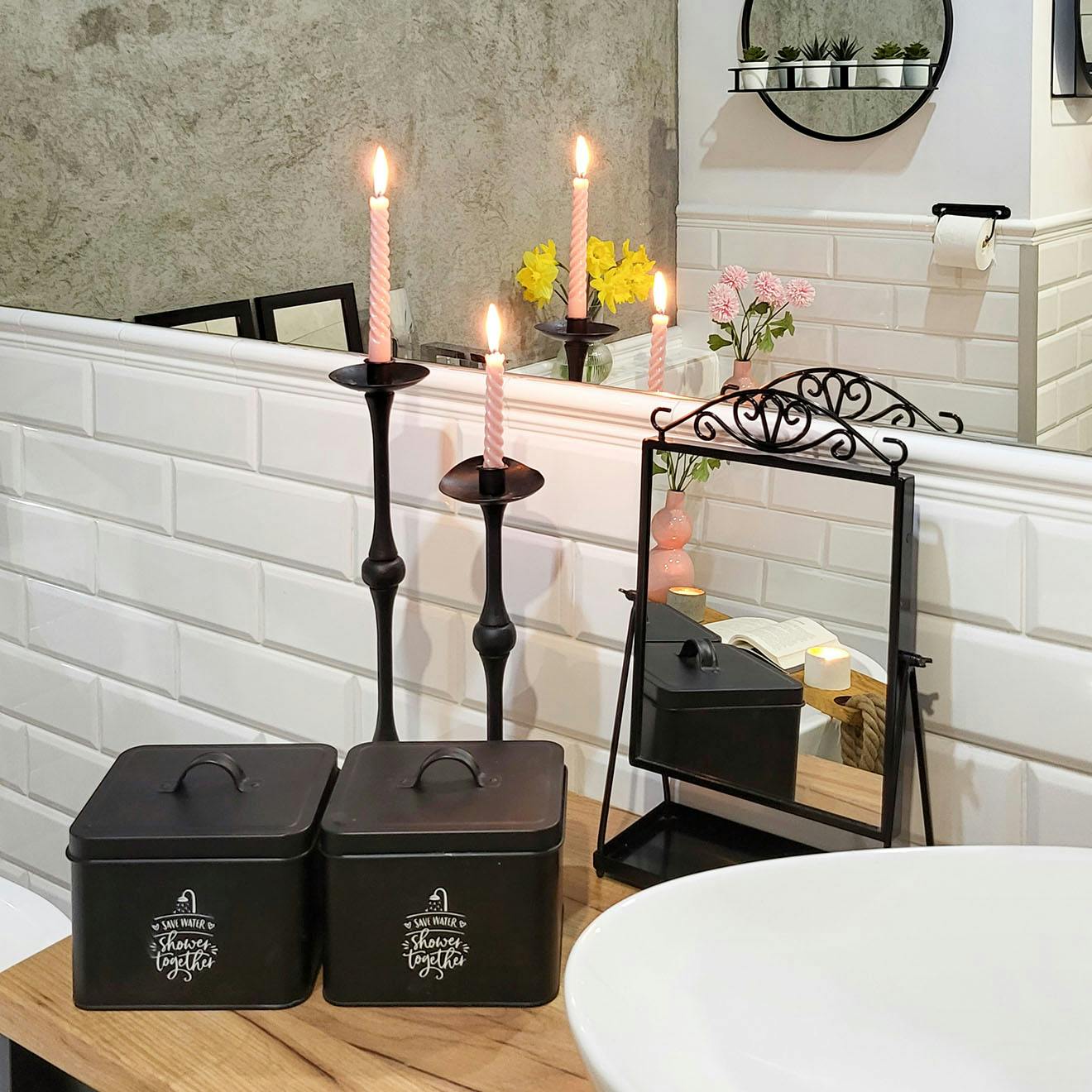 schwarze Behälter, Spiegel und dekorative Kerzenständer auf der Badezimmertheke