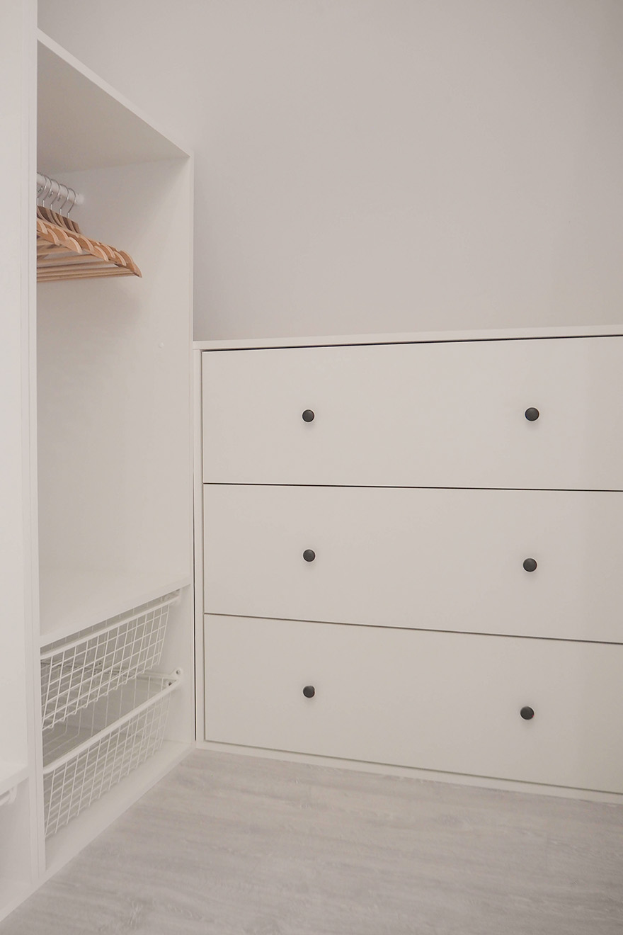 weiße Kleiderschränke in einem kleinen Ankleidezimmer im Dachgeschoss