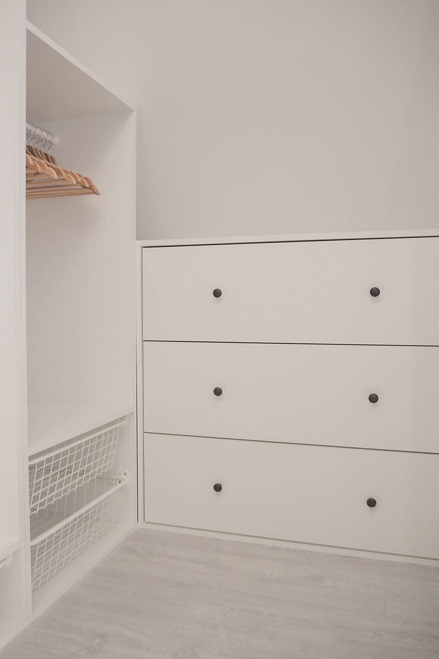 weiße Kleiderschränke in einem kleinen Ankleidezimmer im Dachgeschoss