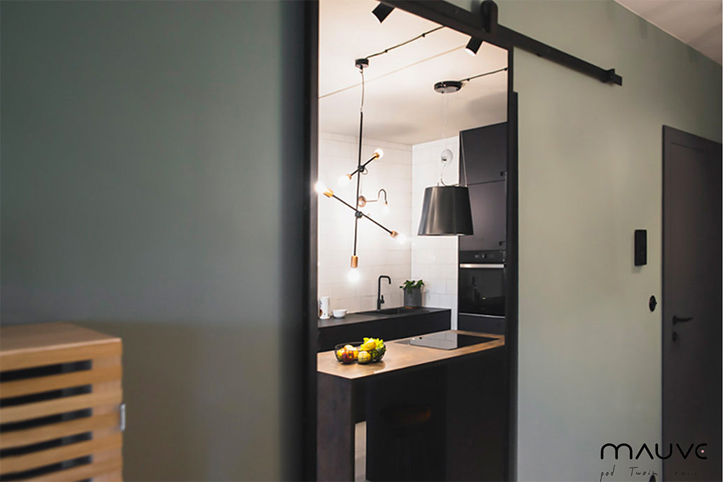 großer Spiegel in einem Metallrahmen, industrielle Pendelleuchten, Metalllampen für die Küche, schwarze Metalllampen über der Insel in der Küche