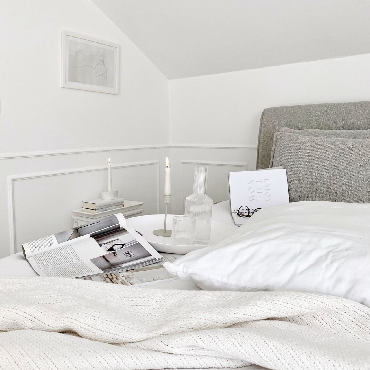 biała pościel na łóżku z tapicerowanym zagłówkiem