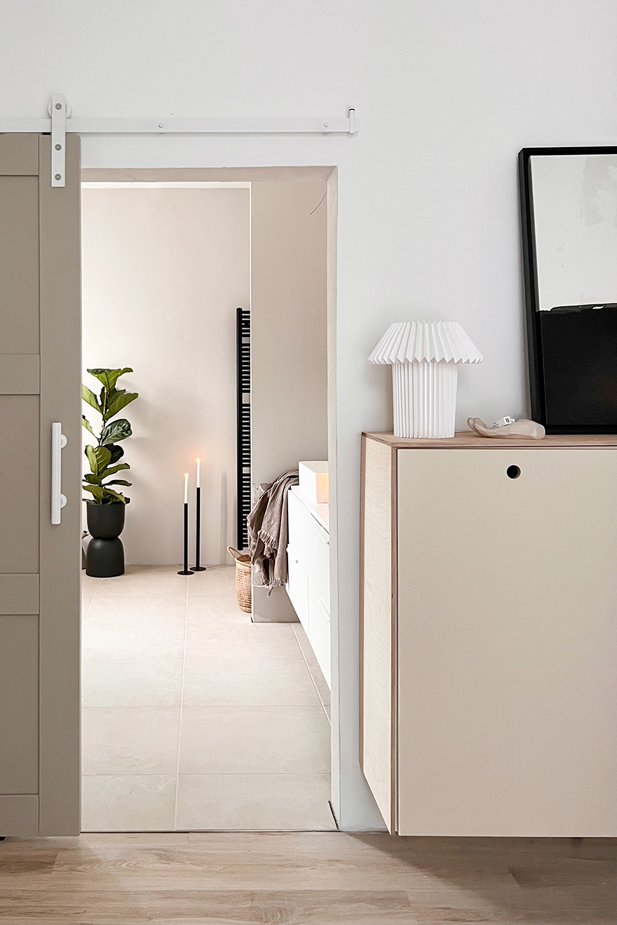 Eingang zum Badezimmer in Grau- und Beigetönen mit schwarzen Accessoires