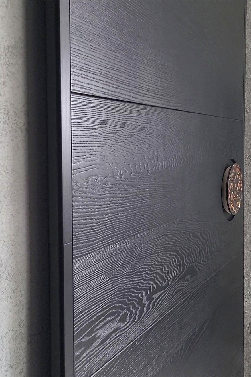 czarne drewniane drzwi przesuwne z okrągłą klamką