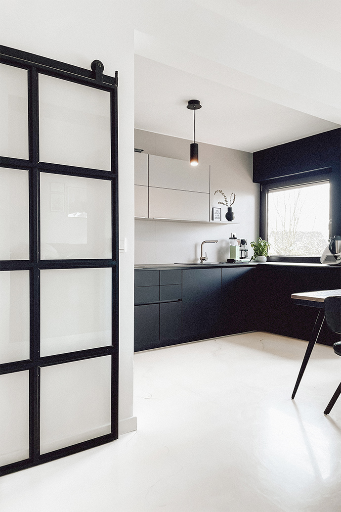 czarno biała, otwarta kuchnia w minimalistycznym klimacie z jasną podłogą