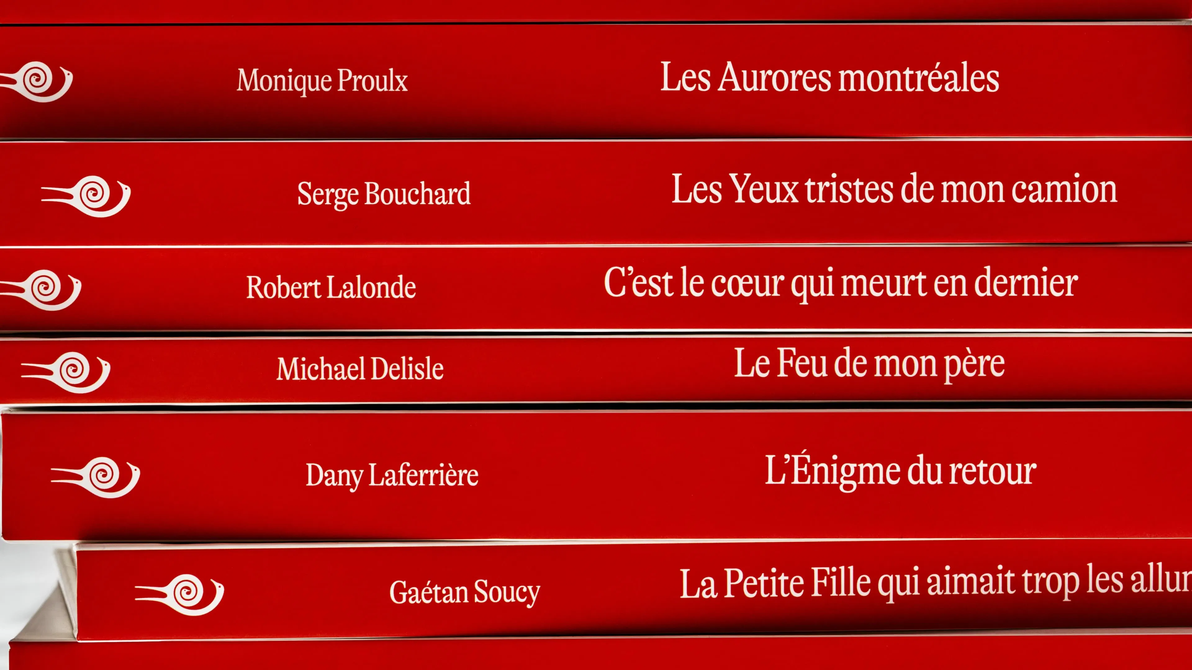 Red book spines stacked horizontally, each with white text displaying French titles and authors.