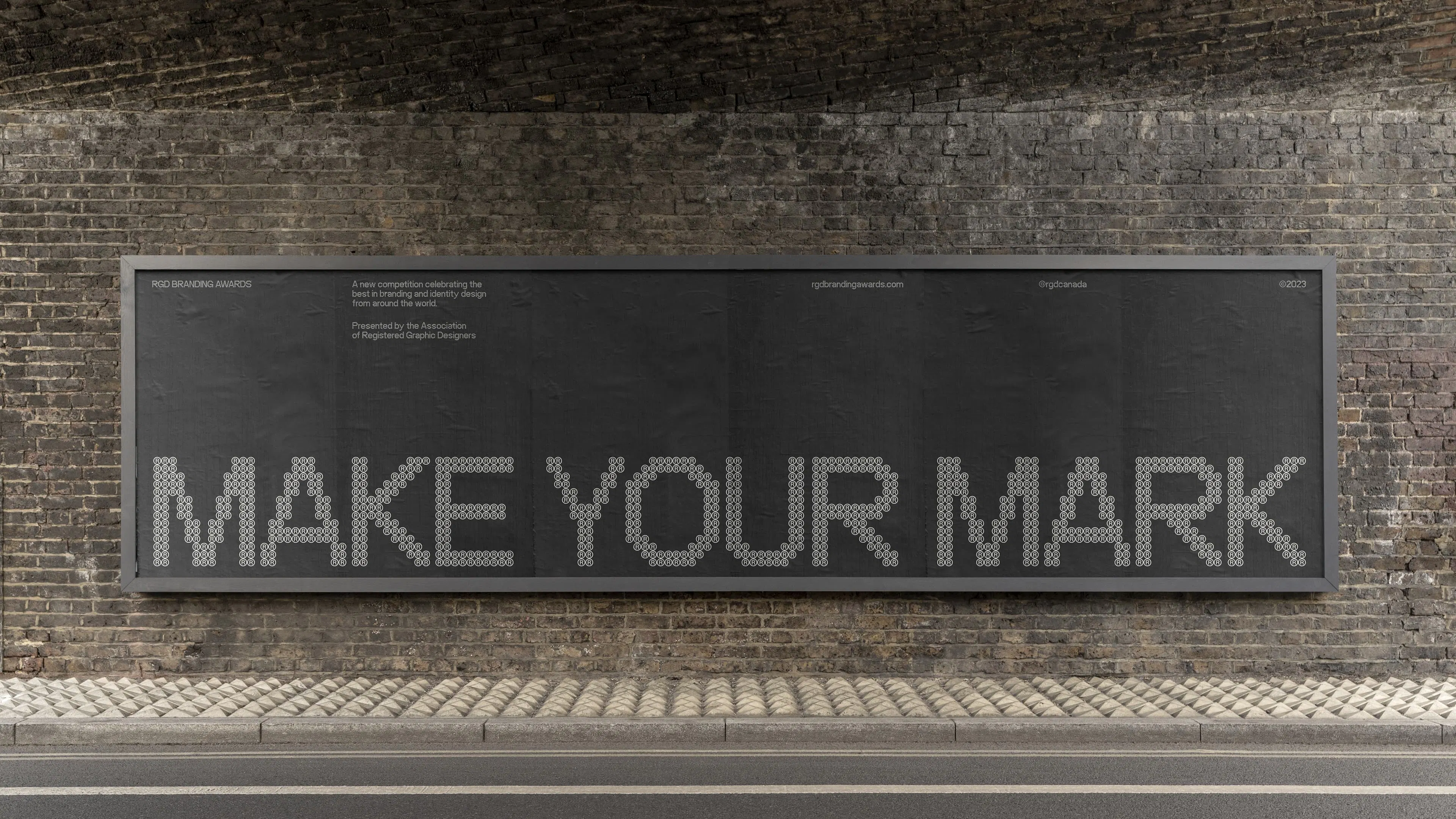 A large brick wall features a blackboard with the words "MAKE YOUR MARK" in bold, white letters made of small registered trademark symbols.