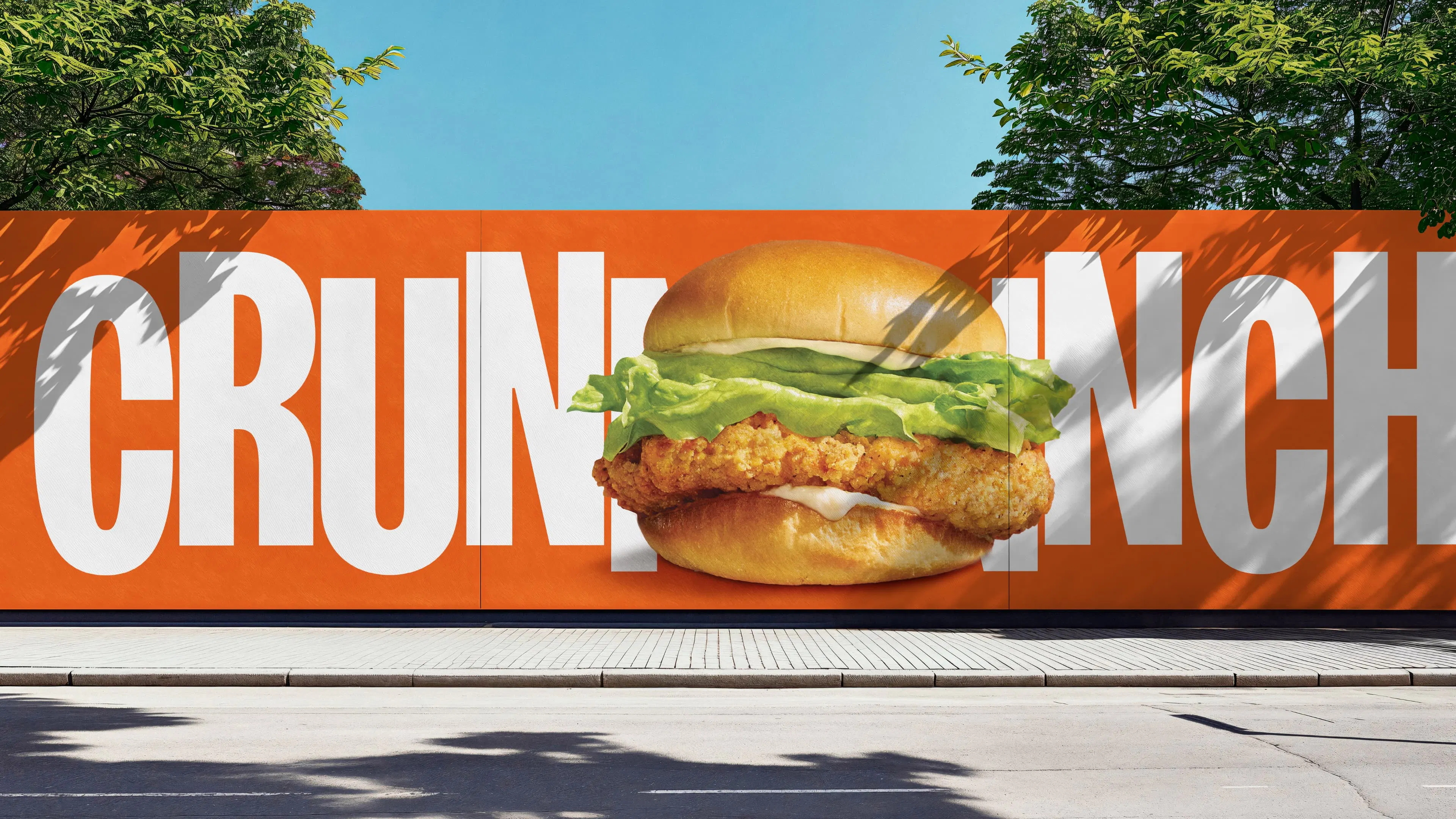A large billboard displays a crispy A&W chicken sandwich with lettuce and mayonnaise, set against an orange background with the word “CRUNCH” in bold white letters partly visible.