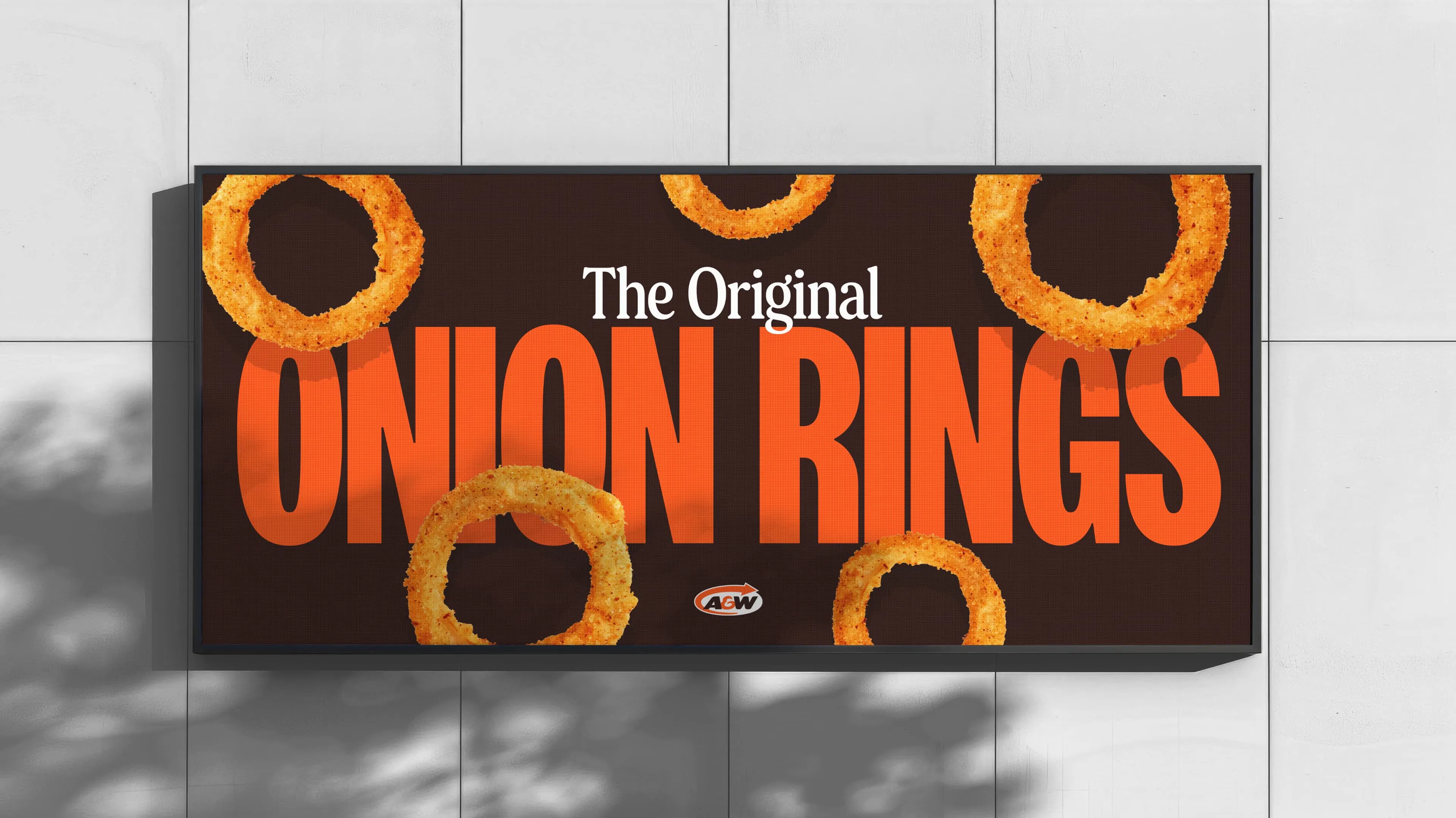 Billboard advertising onion rings with text "The Original ONION RINGS" on a brown background with A&W logo.