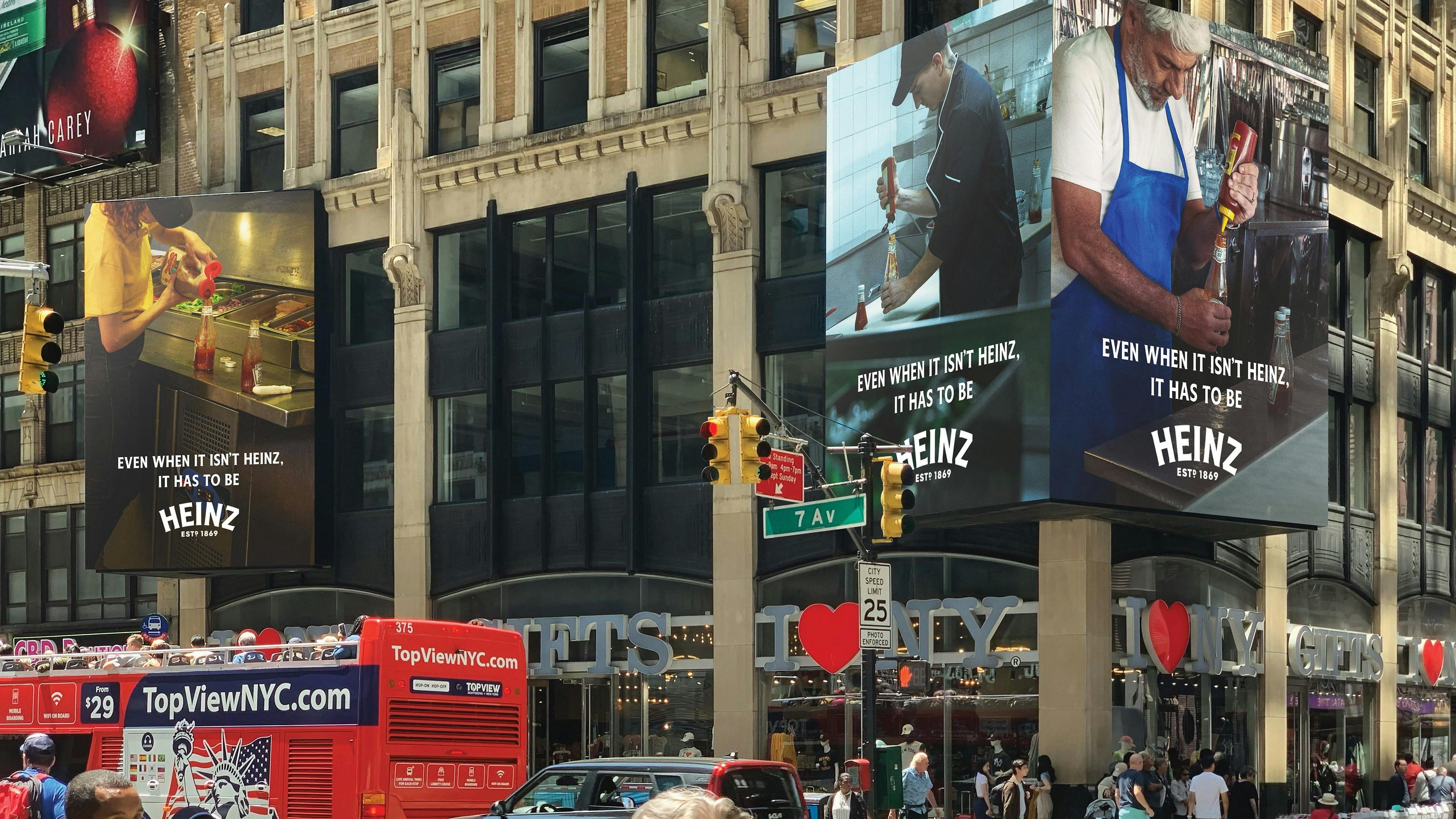 De grands panneaux publicitaires en plein cœur de Manhattan, New York, affichent des images de différentes personnes utilisant du ketchup Heinz. 