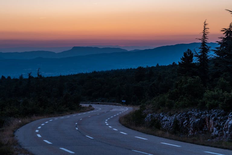 Straße in den Bergen bei Sonnenuntergang