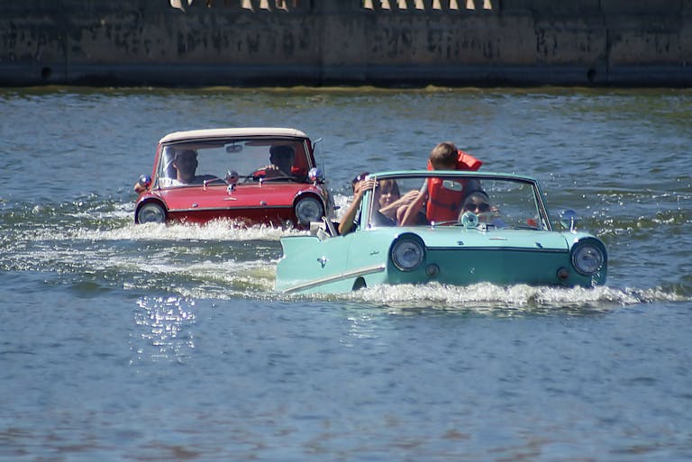 Zwei Schwimmautos auf dem Wasser Zwei Schwimmautos auf dem Wasser