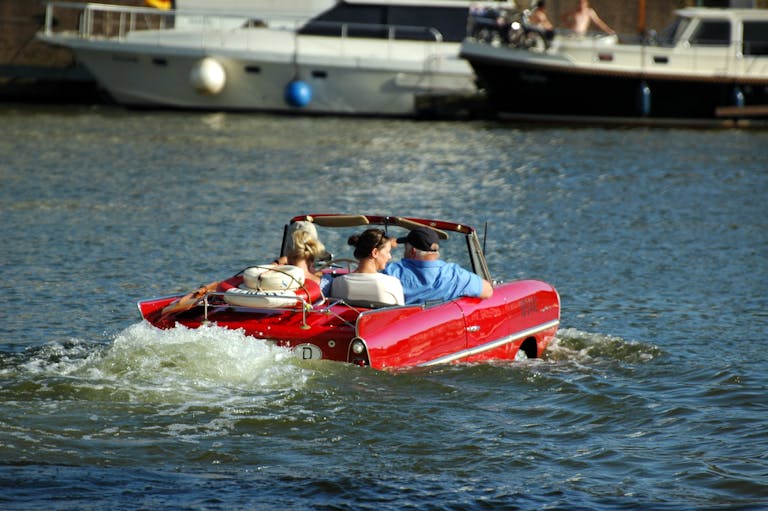 Rotes Amphicar fährt auf dem Wasser