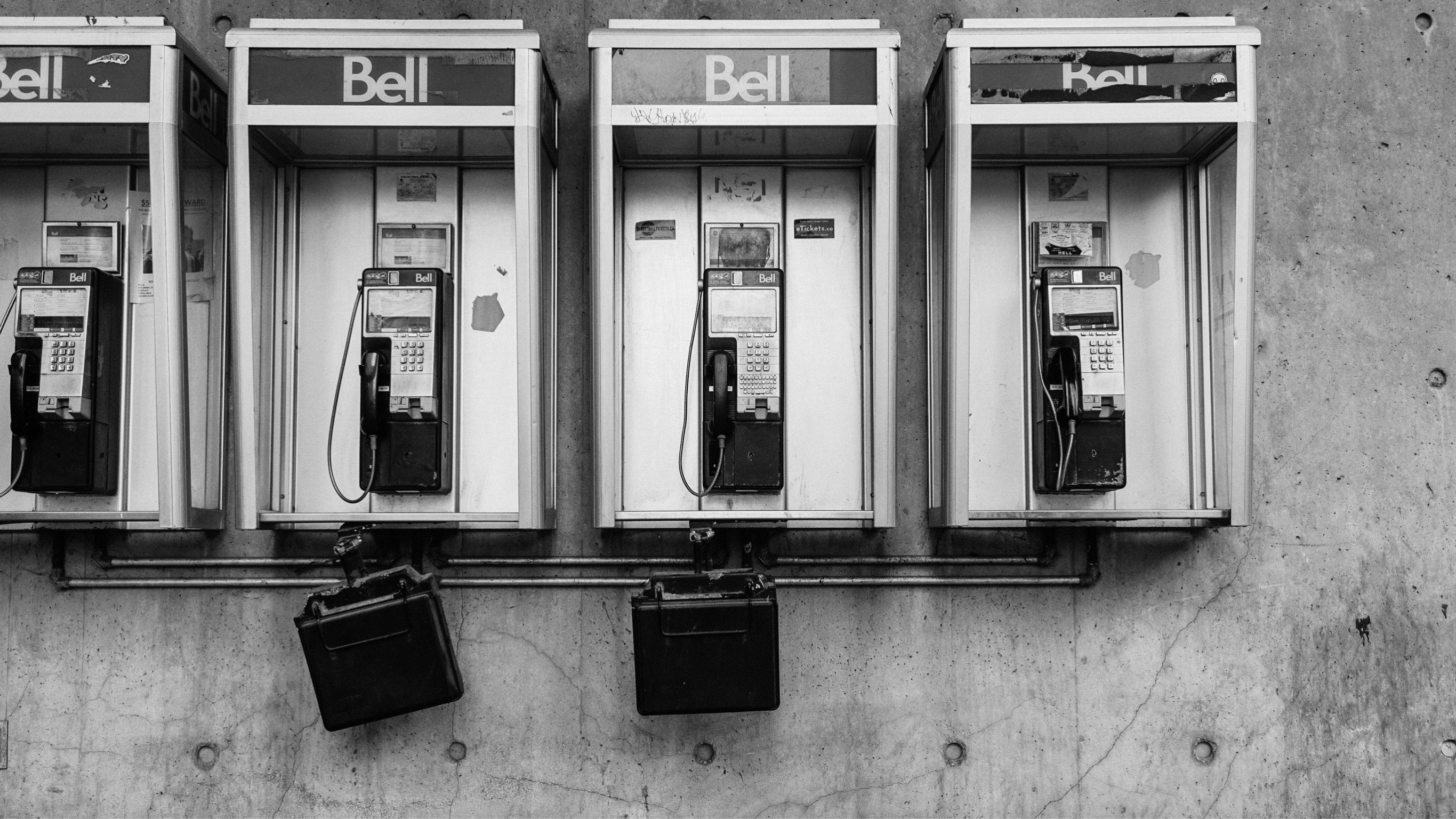 Mehrere alte Münztelefone nebeneinander an einer Wand.