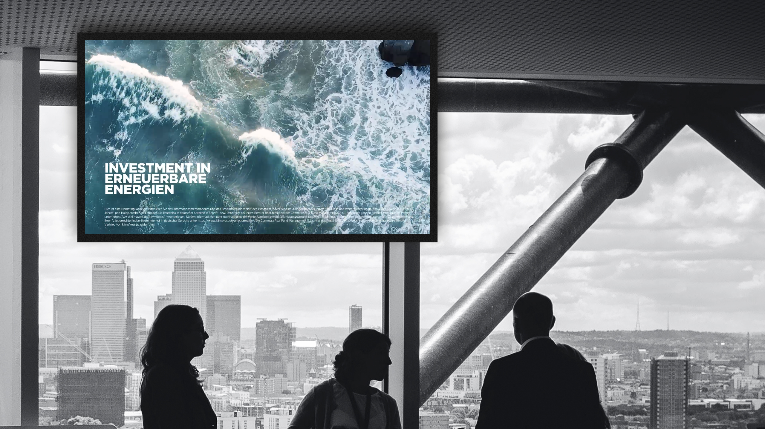 Drei Menschen vor einem Fenster mit Skyline-Ausblick neben einem Bildschirm mit klimaVest Werbekampagne "Invest in Infinity".