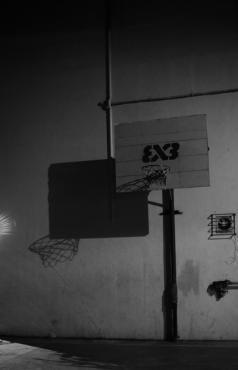 Basketballkorb, der große Schatten an eine Wand wirft.