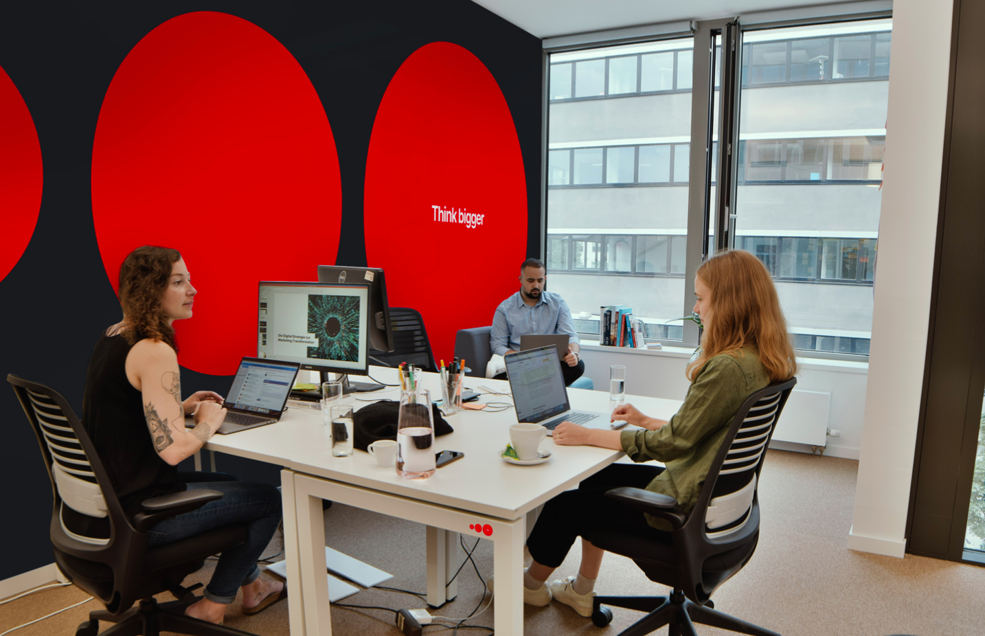 Bild mit drei Mitarbeiter:innen aus dem Return Büro.