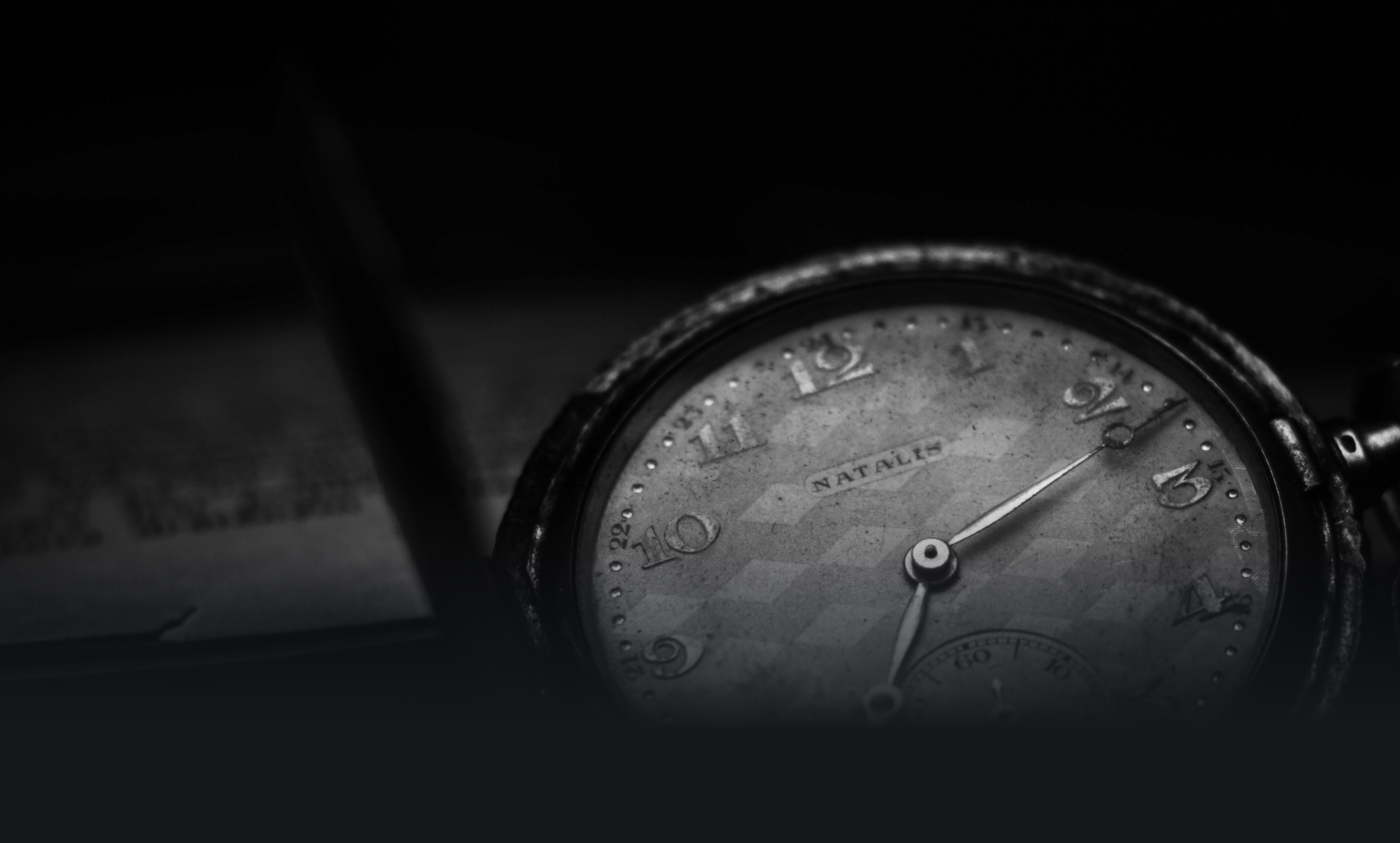 Nahaufnahme einer alten Taschenuhr der Marke NATALIS, mit abgenutztem Zifferblatt und römischen Zahlen.