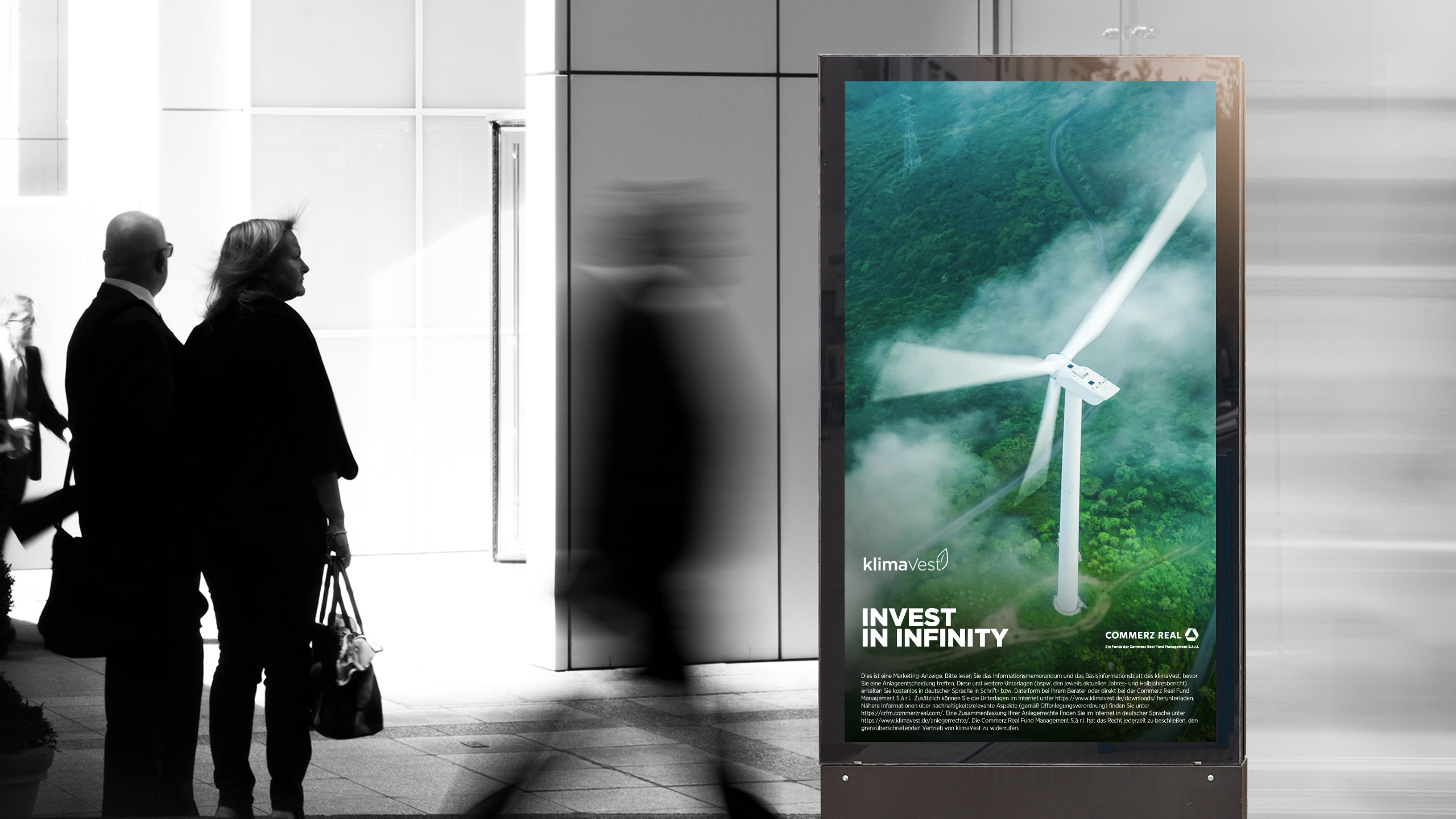 klimaVest Werbebanner, an dem mehrere Menschen vorbeilaufen.