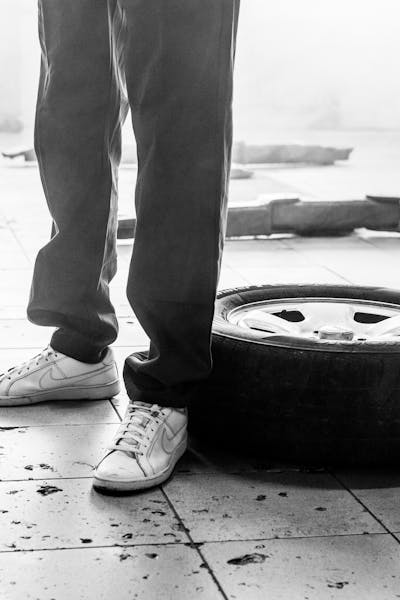 Beine stehend vor einem Reifen auf dem Boden