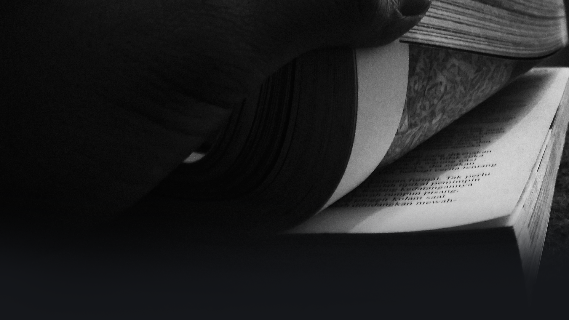 Kontrastreiches Bild von einem Buch, das an einer Ecke aufgeschlagen wird.