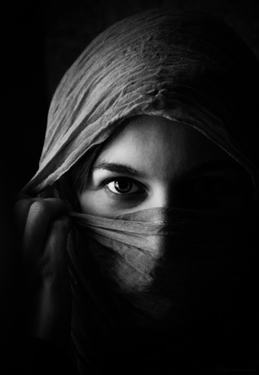 Nahaufnahme von einer Frau, Nase, Mund und Kopf sind von einem Tuch bedeckt.