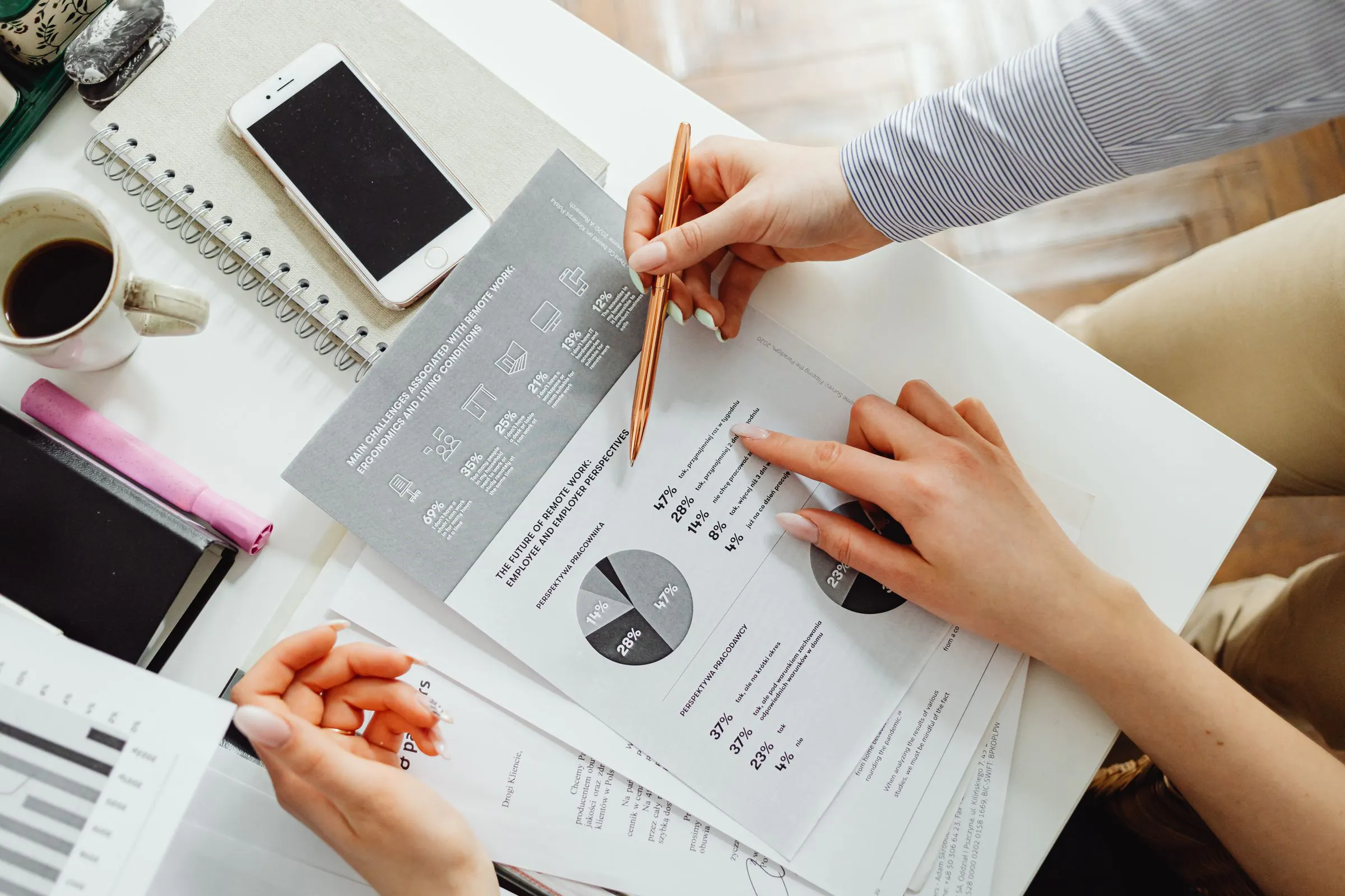 Duas pessoas revisando um relatório, caneta sobre o gráfico: a diligência lê o que o pitch deixou de fora.