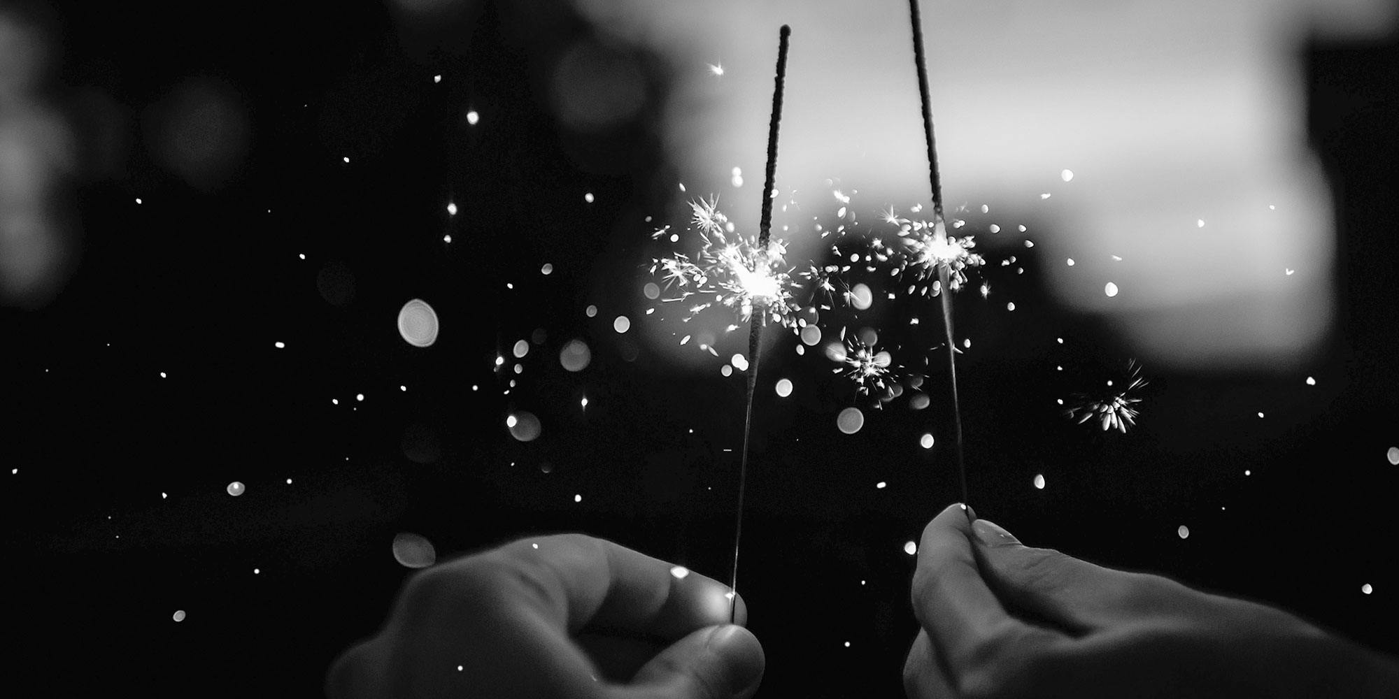 Two hands holding sparklers