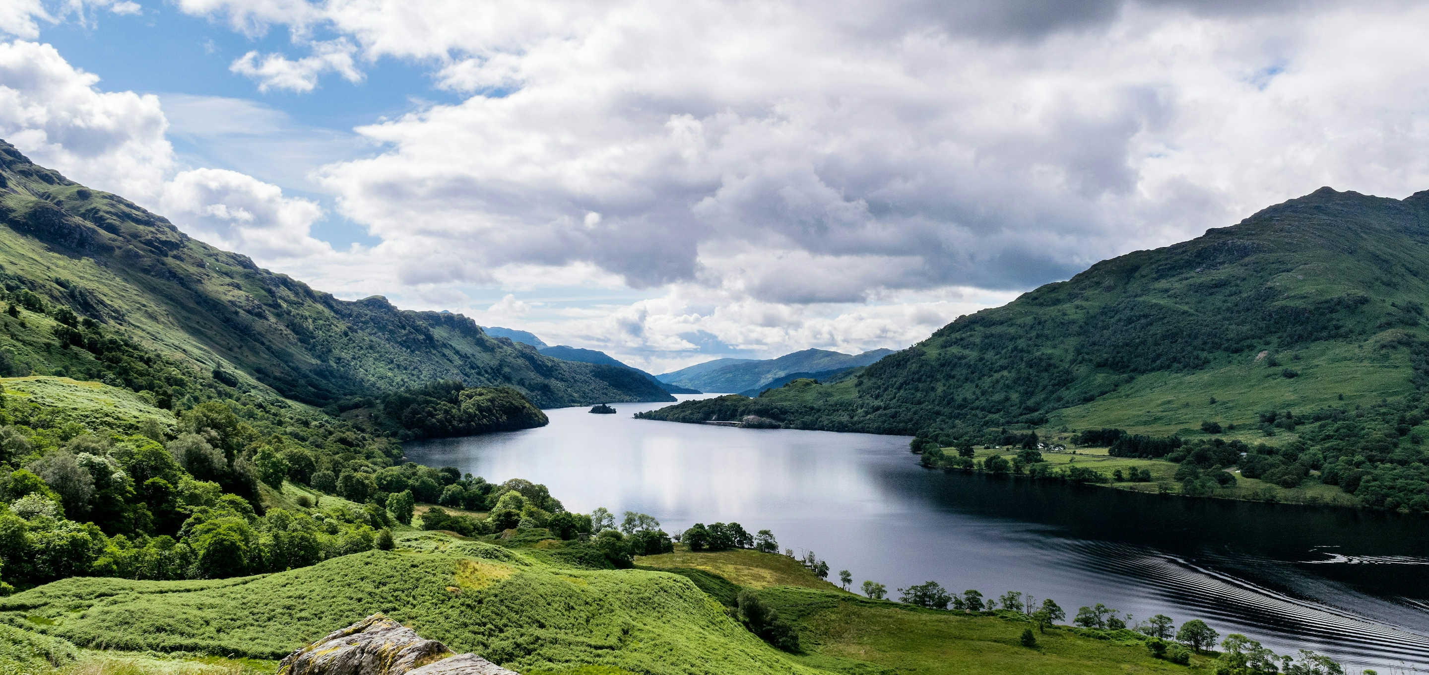 Lake with green woodland on the surrounding hills