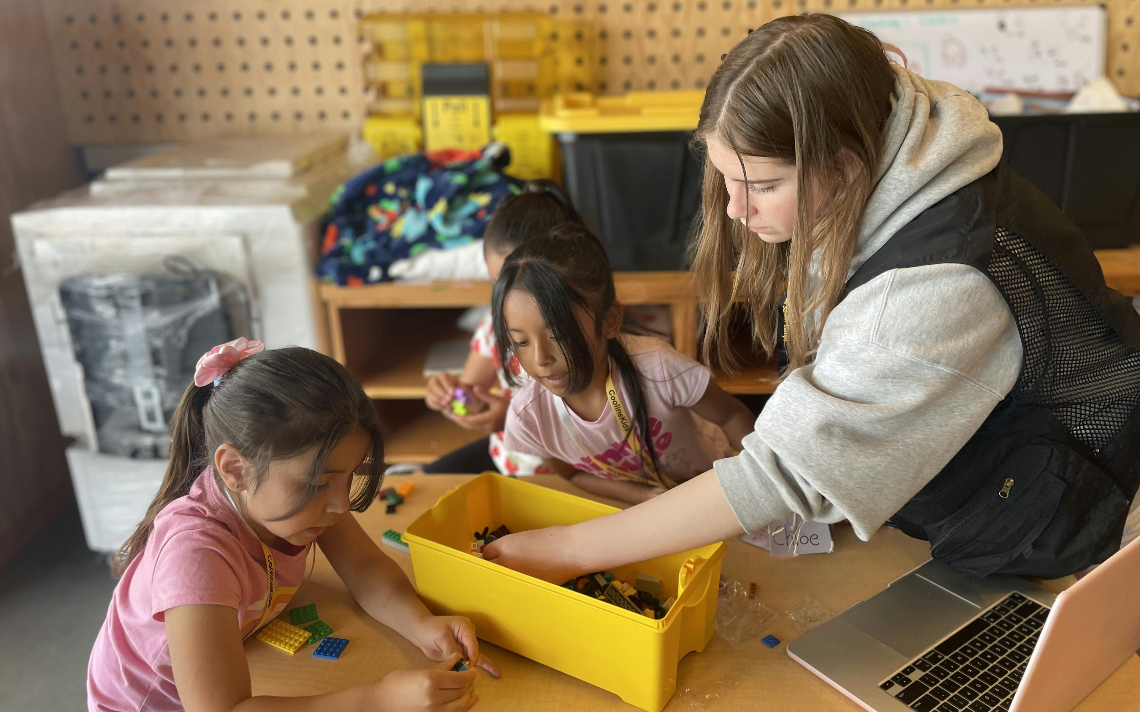 Volunteer assisting students in lego activity