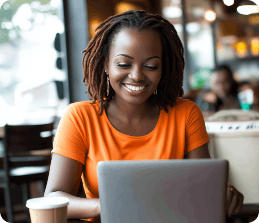 woman smiling and working on a laptop