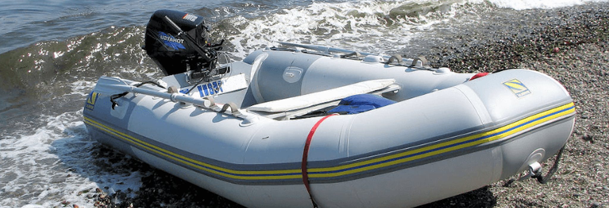 Zodiac pvc dinghy on a beach after having a repair