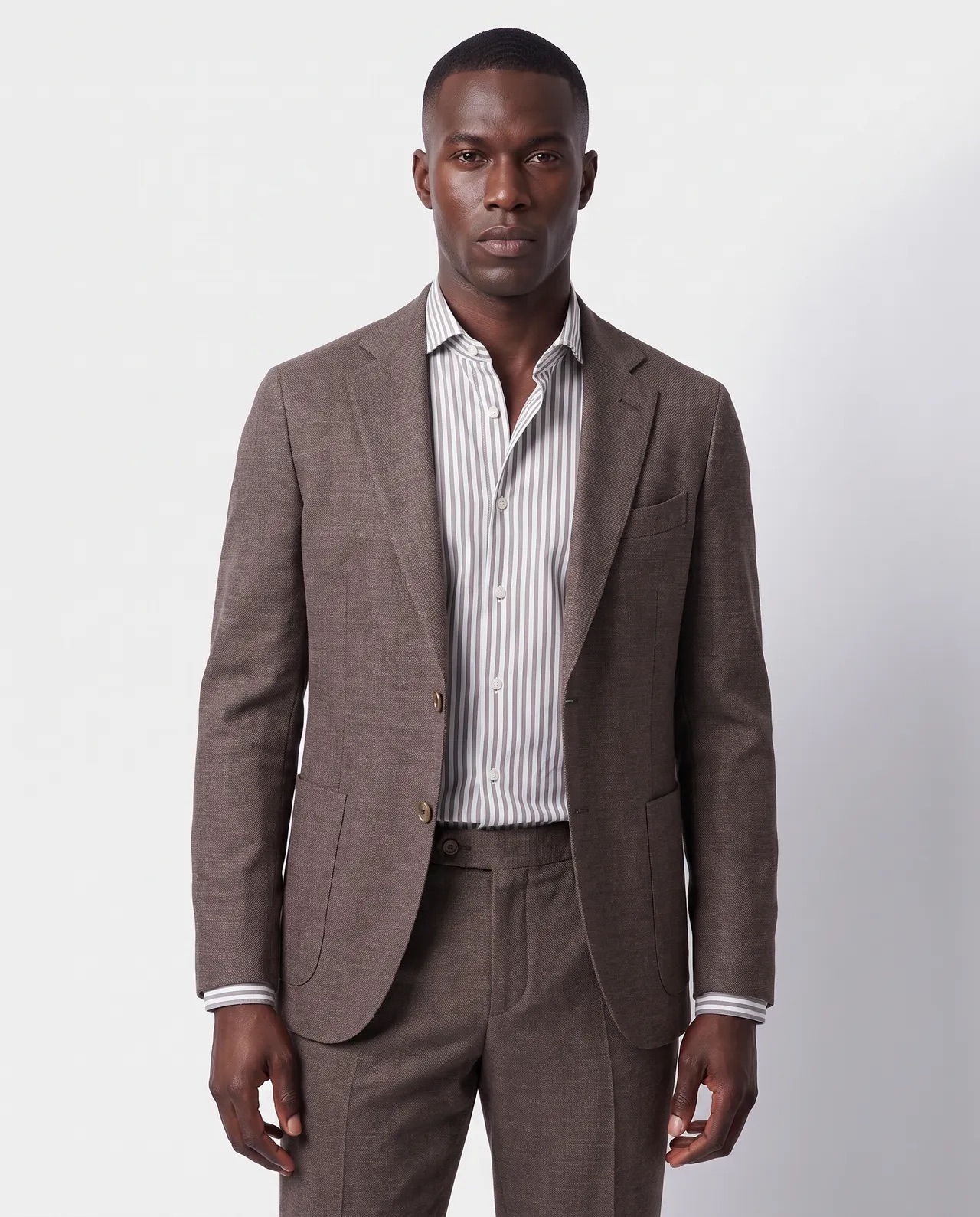 Model in het bruine colbert met gestreept overhemd, driekwart in beeld, gemaakt met Fashion Flow (AI-beeld)