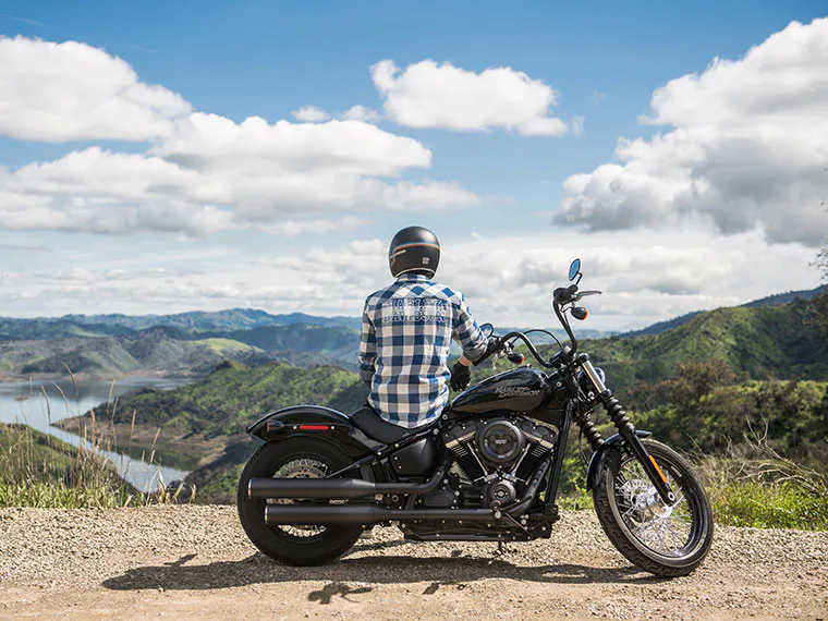 Motociclista tomando un descanso en un mirador panorámico.
