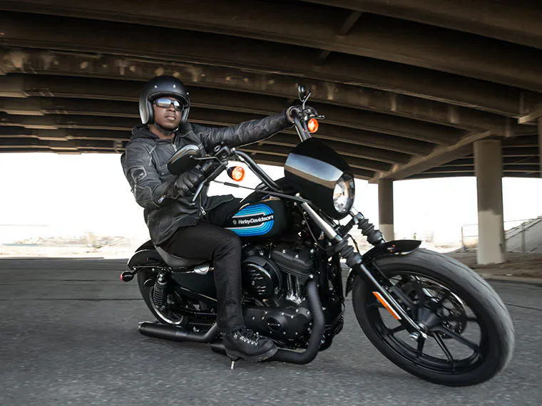 Homem em cima de uma motocicleta Harley-Davidson na cidade.