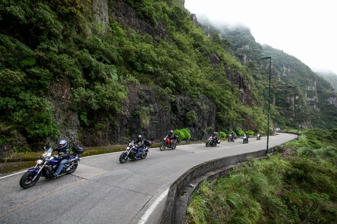 grupo de motociclistas dirigindo em uma estrada sinuosa tendências de motocicleta ao longo do tempo mais populares