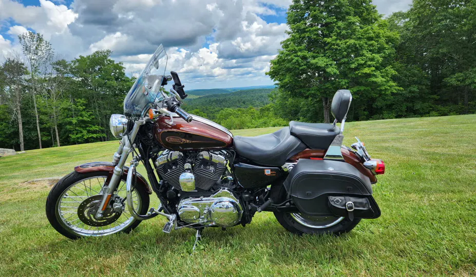foto de aluguel de motocicleta Harley Davidson (Sportster) estacionada em um campo gramado