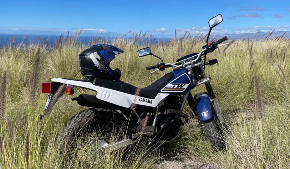 2017 Yamaha TW200 estacionada em grama bem alta em uma costa em Hawaii; locação de motocicletas Honolulu, Hawaii