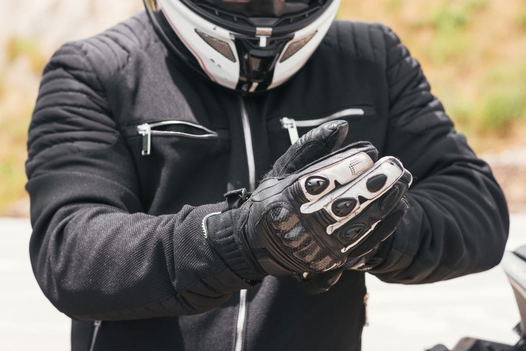 motorcycle rider putting on gloves how to stay safe with protective gear