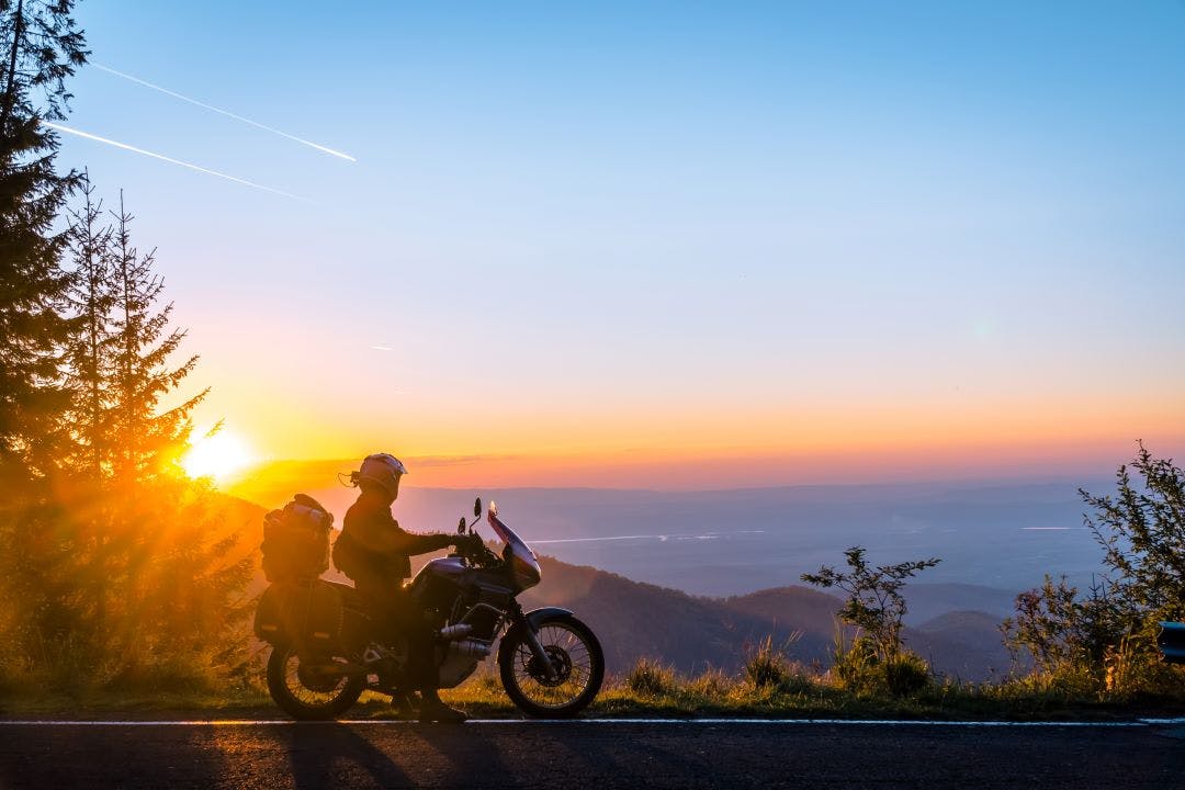 picture of motorcyclist on the edge of overlook with travel gear trip packing list