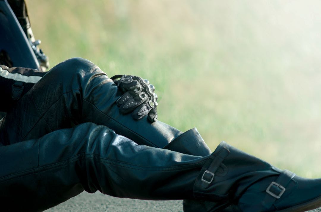 picture of woman sitting down showing her riding pants, gloves, and boots guide to motorcycle protective gear