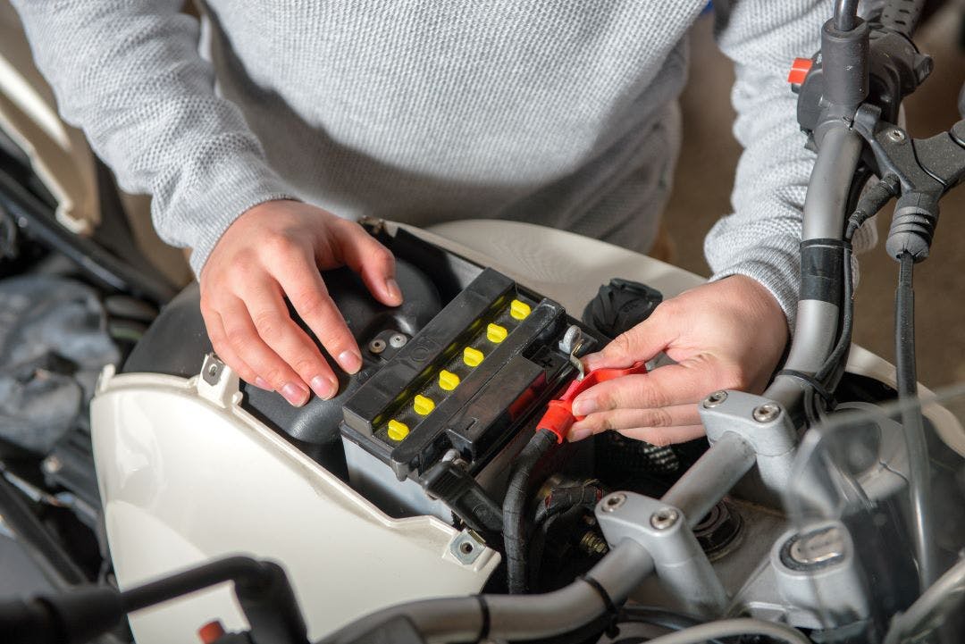 man changing battery in motorcycle how to change your motorcycle battery 