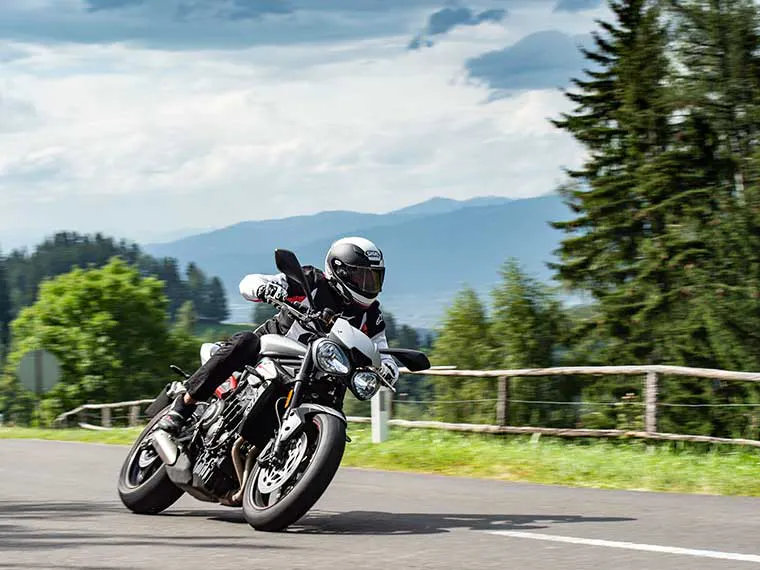 Motociclista de Triumph recorriendo la campiña.