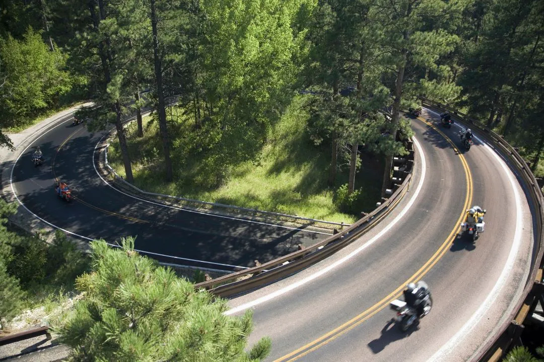 grupo de motociclistas fazendo turismo em estrada muito ventosa melhores motocicletas para viajar