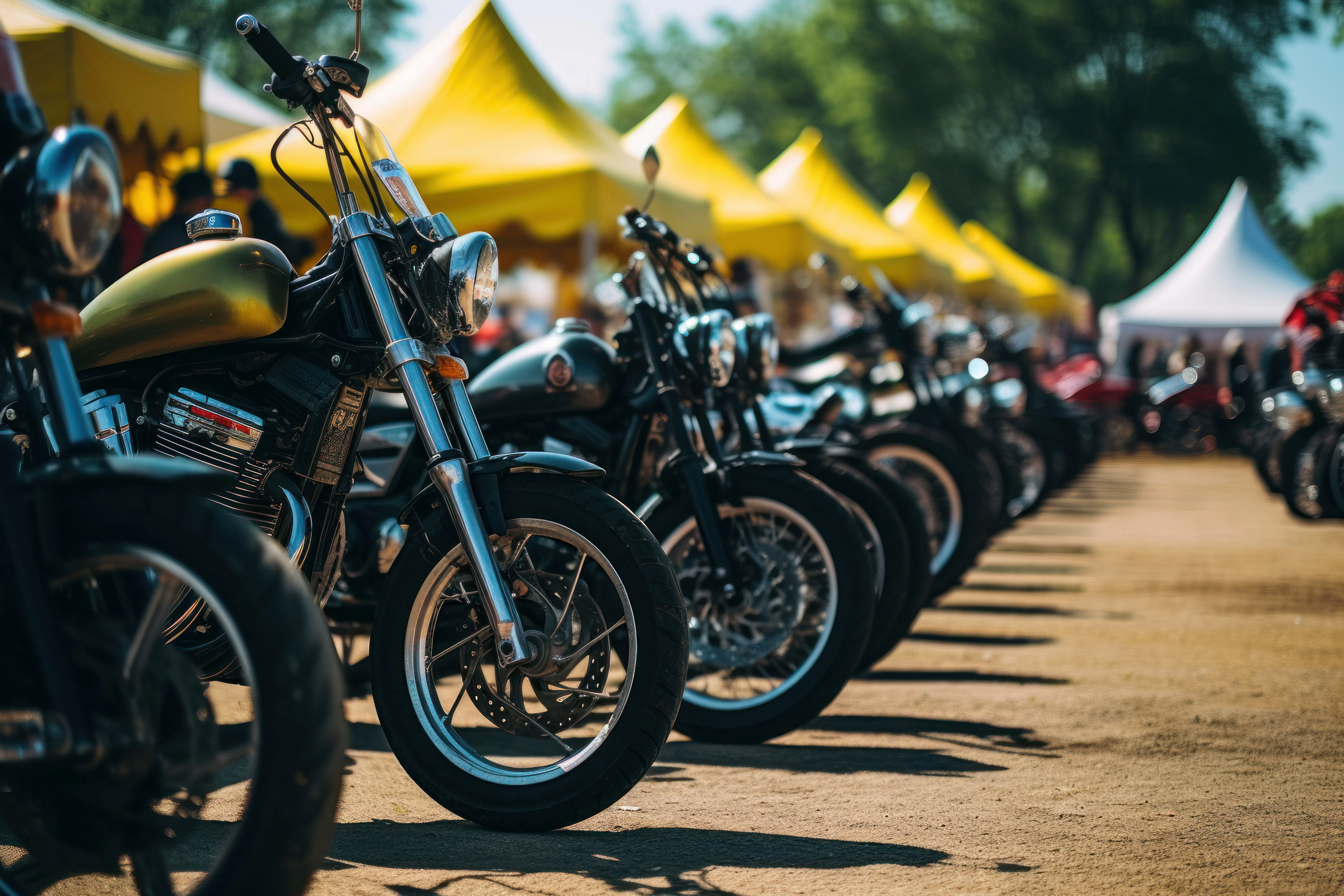 Row of parked motorcycles at a rally event with yellow tents in the background