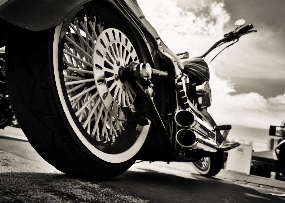 ground view of rear tire and pipes on motorcycle Best Used Motorcycles You Can Buy Today