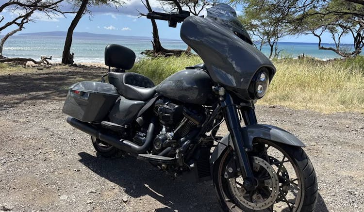 image of grey harley street glide motorcycle rental in hawaii in front of ocean