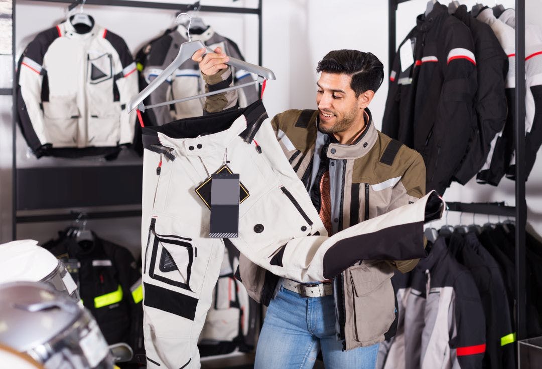 Adult american man is choosing new pants for motorbike in the moto store Essential Florida Riding Gear for the State’s Unique Climate